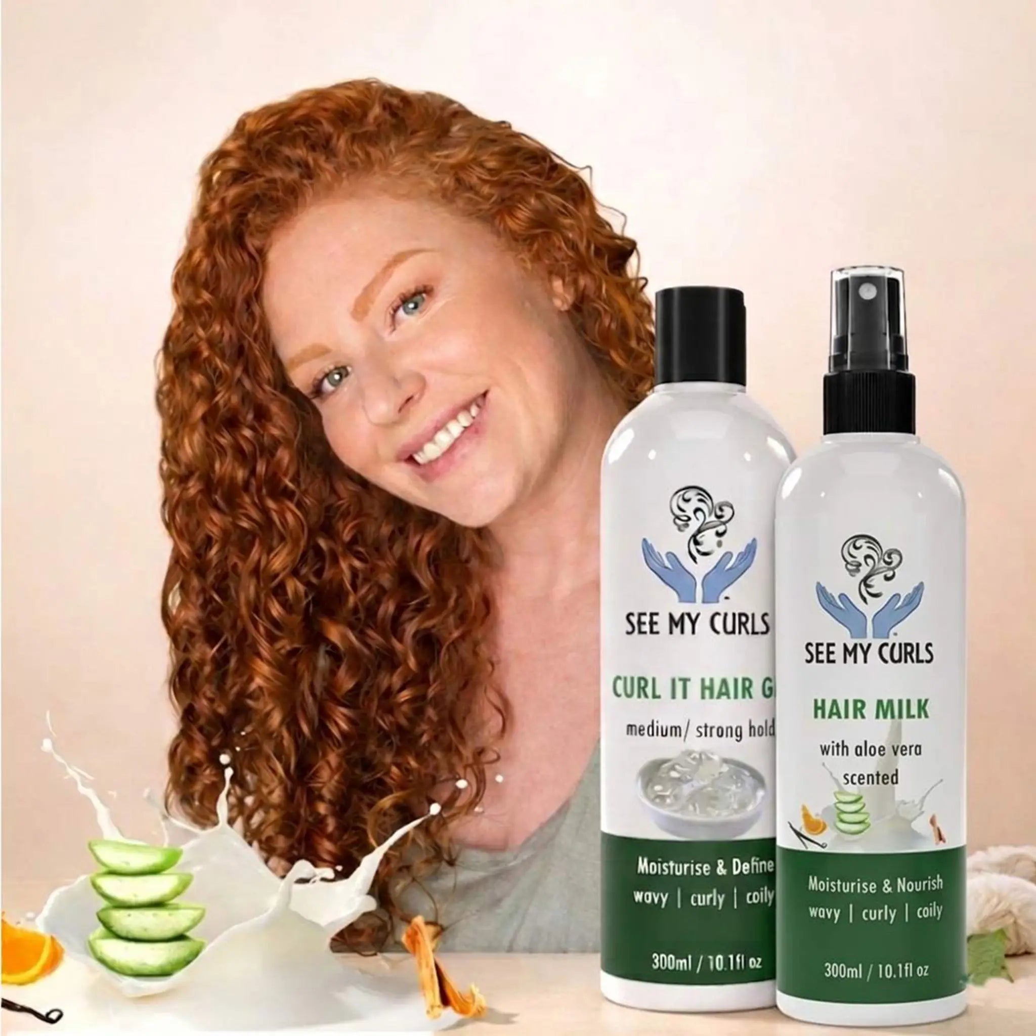 A woman with vibrant, voluminous red curly hair smiling next to See My Curls "Curl It Hair Gel" and "Hair Milk" spray. The scene features natural ingredients including sliced aloe vera splashed in milk and orange slices, highlighting the moisturizing natural formula for curly and coily hair types.